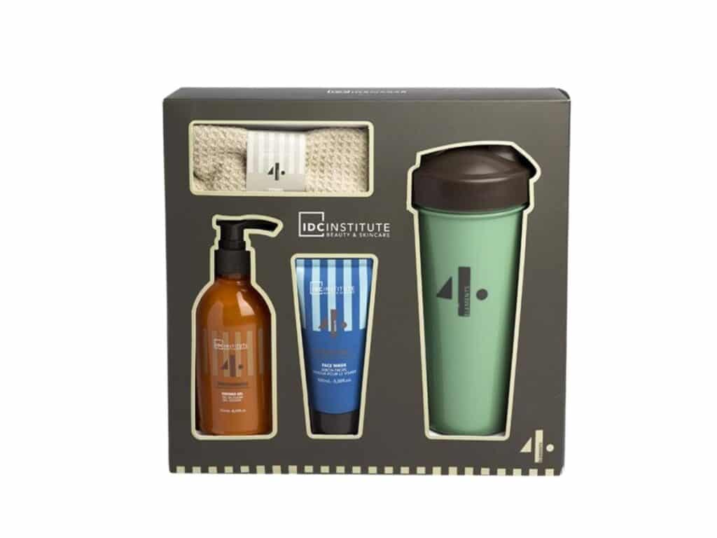 Set de Regalo Gimnasio que incluye gel de ducha, limpiador facial, toalla de algodón beige y botella verde reutilizable en un elegante empaque.