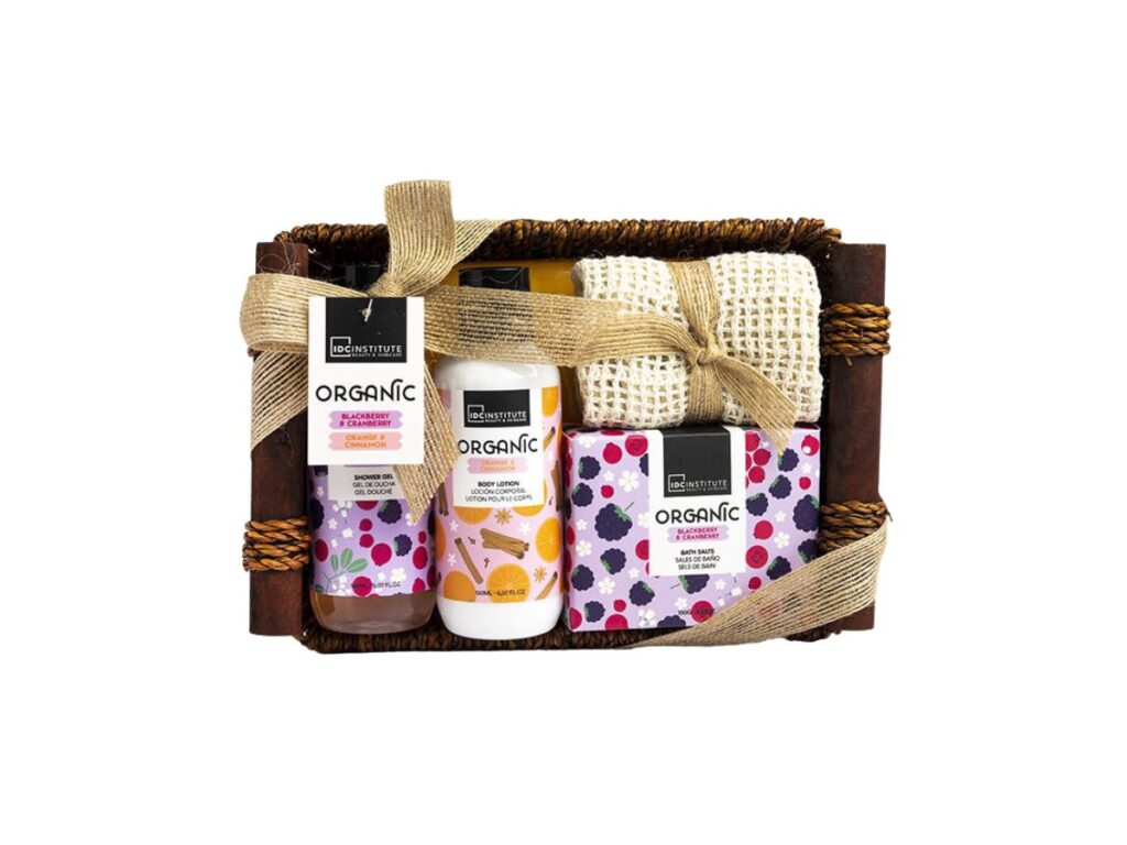 Cesta de baño orgánica decorativa con gel de ducha, crema, sales de baño y toalla exfoliante, presentada en una elegante cesta de madera con cinta decorativa.