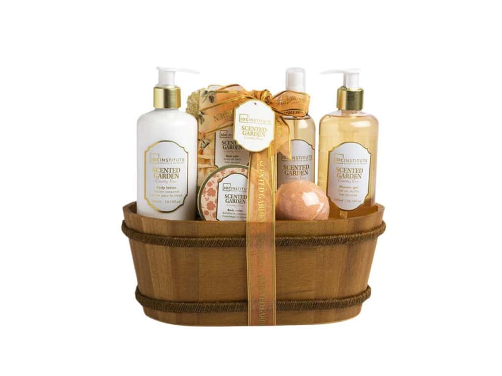 Cesta regalo aromática Country Rose que incluye gel de ducha, loción corporal, exfoliante, bomba de baño, sales de baño y esponja, en una elegante presentación de madera.